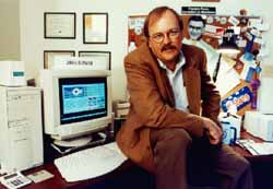 Carlson seated on his desk, circa 1994.